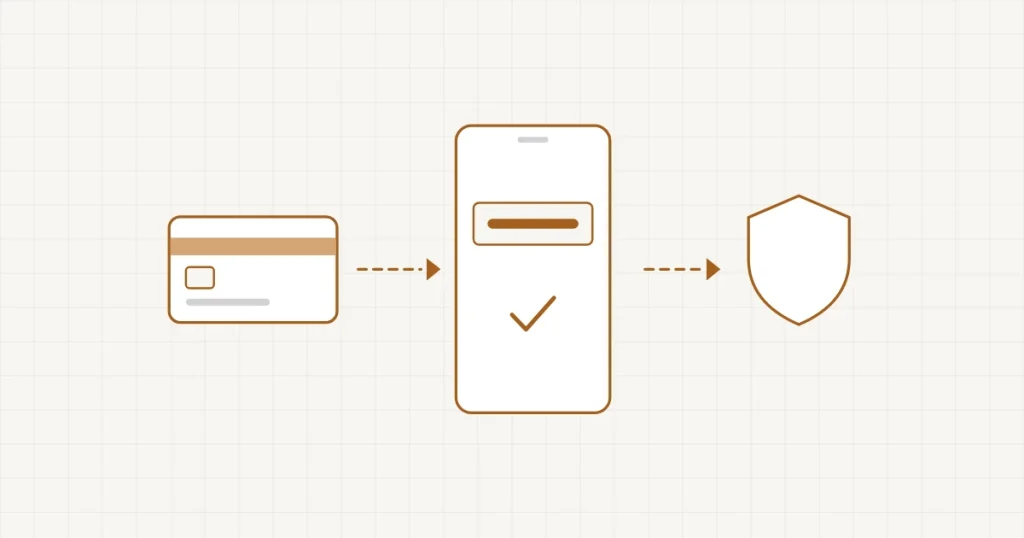 Un téléphone affichant un code de validation à côté d’une carte bancaire et d’un écran de paiement