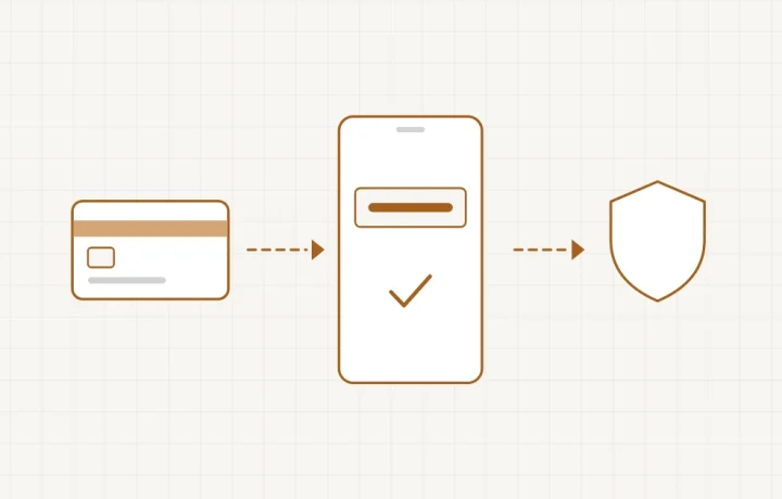 Un téléphone affichant un code de validation à côté d’une carte bancaire et d’un écran de paiement