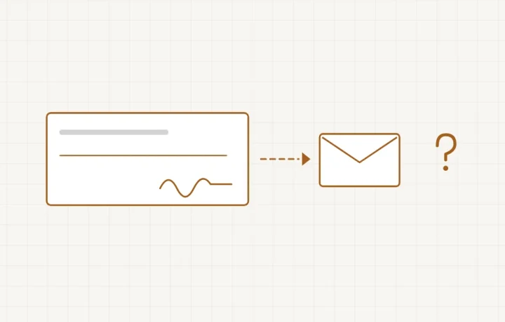 Un chèque glissé dans une enveloppe posée à côté d’un écran de boutique en ligne
